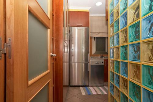 uma cozinha com uma porta aberta para um frigorífico em Casa Punta Balea, en el centro em Cangas