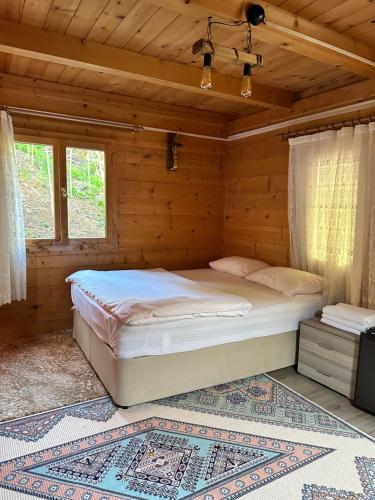 a bedroom with a bed in a wooden room at Ayder Bulut Dağevi Bungalow in Ayder Yaylasi