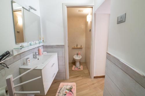 ein weißes Bad mit einem Waschbecken und einem WC in der Unterkunft ROSE HOUSE in Syrakus