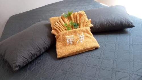 a bed with two pillows on top of it at Residencial T2 no Parque Verde in Quinta do Conde