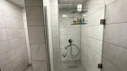 La salle de bains est pourvue d'une douche avec une porte en verre. dans l'établissement Notus Suites, à Antalya