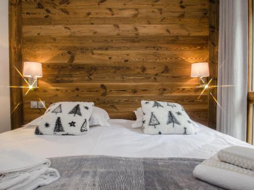 - une chambre dotée d'un mur en bois et d'un lit avec des oreillers dans l'établissement Appartement 3 étoiles, WiFi, parking, balcon à Chamonix - FR-1-343-201, à Chamonix-Mont-Blanc