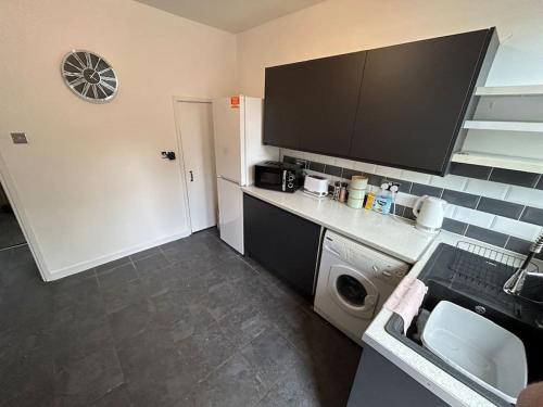 uma cozinha com um lavatório e uma máquina de lavar roupa em Bright & Central Home em Church Coppenhall