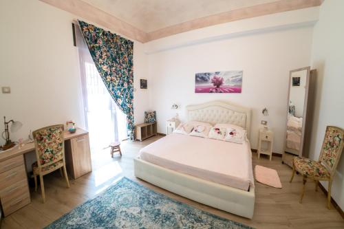 a bedroom with a bed and two chairs at ROSE HOUSE in Siracusa