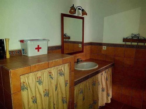 y baño con lavabo y espejo. en Casa Rural Paraiso de Emilia en La Aulaga