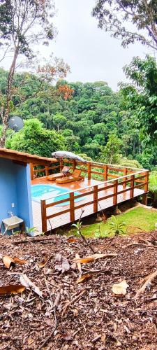 a house with a deck and a swimming pool at Cantin da Mata in Domingos Martins
