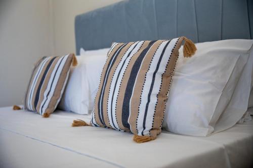 2 almohadas sentadas encima de una cama en ARTEMIS SUITE, en Agia Marina