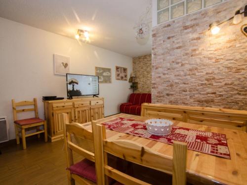 une salle à manger avec une table et un mur de briques dans l'établissement Studio cosy à Chamonix Sud, proche centre, balcon, 4 pers, parking, WiFi - FR-1-343-235, à Chamonix-Mont-Blanc