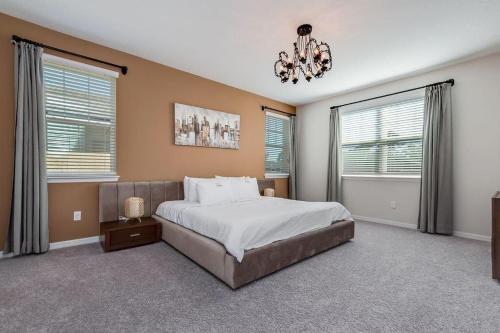 a bedroom with a large bed and a chandelier at BSV1529 - Luxury 7 Bedroom 5 Bathroom Villa in the Desirable Solara Resort in Kissimmee