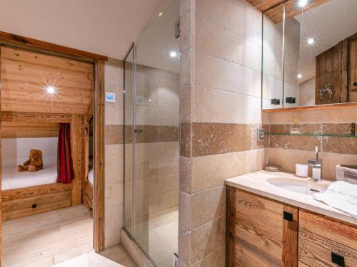 La salle de bains est pourvue d'un lavabo et d'une douche avec un ours en peluche. dans l'établissement Cocon raffiné 5 pièces skis aux pieds à Val-d’Isère avec wifi, cheminée et garage - FR-1-694-11, à Val dʼIsère