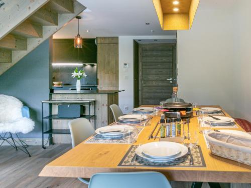 - une salle à manger avec une table et des assiettes dans l'établissement Appartement de Standing en Duplex à Val-d'Isère avec Balcon, Parking et Wifi - FR-1-694-22, à Val dʼIsère