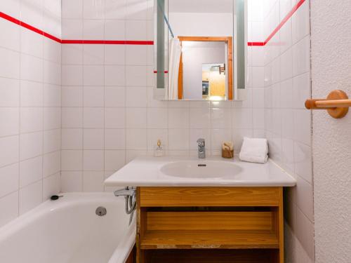 une salle de bain avec un lavabo, une baignoire et un miroir dans l'établissement Studio cabine au pied des pistes, idéal pour 4 personnes, proche village enfants, parking inclus - FR-1-694-66, à Val dʼIsère