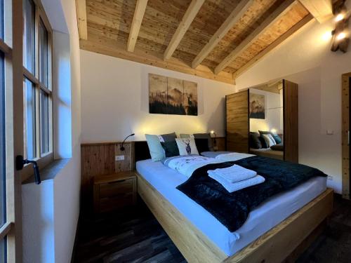 - une chambre avec un grand lit dans l'établissement Riedlfeld Chalet, à Dienten am Hochkönig