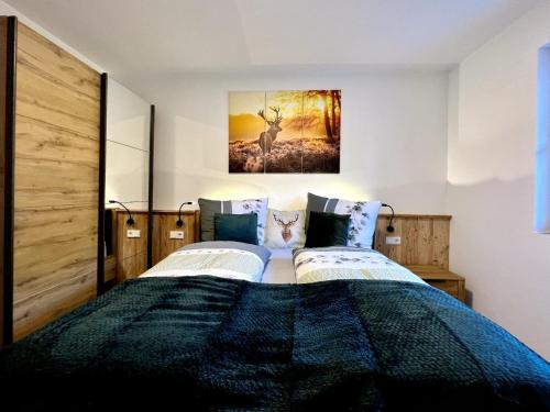 a bedroom with two beds and a painting on the wall at Riedlfeld Chalet in Dienten am Hochkönig