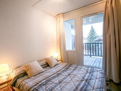a bedroom with a bed and a large window at Appartement skis aux pieds avec parking couvert et WiFi au cœur de Val d'Isère - FR-1-694-259 in Val dʼIsère