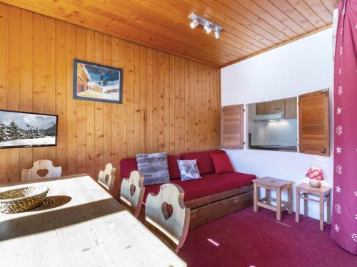 un salon avec un canapé rouge et une table dans l'établissement Studio de 25m² au 6ème étage, proche centre, balcon, Wifi, animaux acceptés - FR-1-694-264, à Val dʼIsère