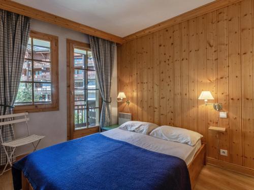 - une chambre avec un lit bleu et des murs en bois dans l'établissement Appartement standing 3 pièces avec terrasse, cheminée, parking et WiFi à Val-d'Isère - FR-1-694-199, à Val dʼIsère