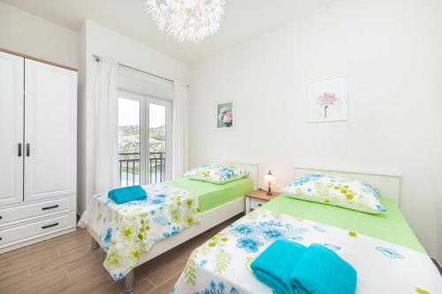 a bedroom with two beds and a window at Lakeview Apartments in Ploče