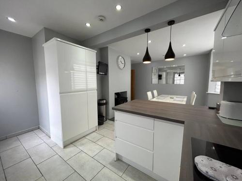 a kitchen with white cabinets and a counter top at Fresh & Spacious House in Rhyl