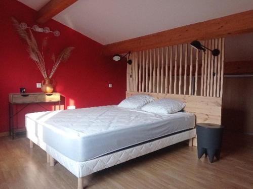 - une chambre avec un lit blanc dans un mur rouge dans l'établissement Maison de charme avec patio et terrasse de toit, à Estagel