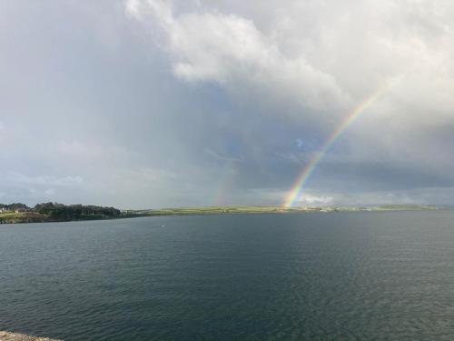 a rainbow in the sky over a body of water at Causeway Country Lodge in Causeway
