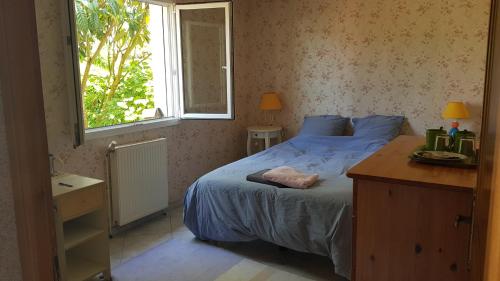 una camera con letto e finestra di Chambre et sdb privées avec accès indépendant et autonome a Saint-Herblain
