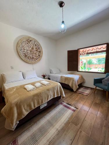 1 dormitorio con 2 camas y ventana en Casa de fadas, en Tiradentes
