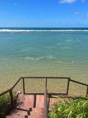 a staircase leading to the beach with the ocean at Nannai Residence - Apartamento Duplex in Porto De Galinhas