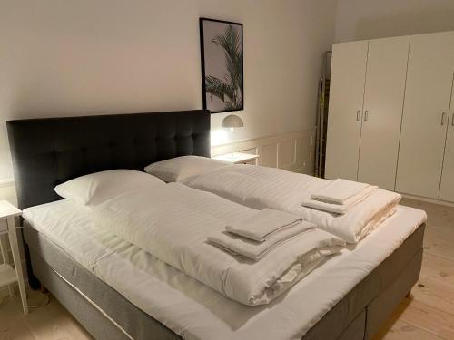 a bed with white sheets and towels on it at City Center Apartments 870 in Copenhagen