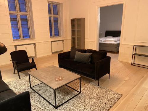 a living room with couches and a table and a bed at City Center Apartments 870 in Copenhagen