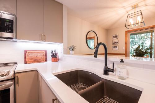a kitchen with a sink and a stove at Arrowhead Point by Outpost Whistler in Whistler
