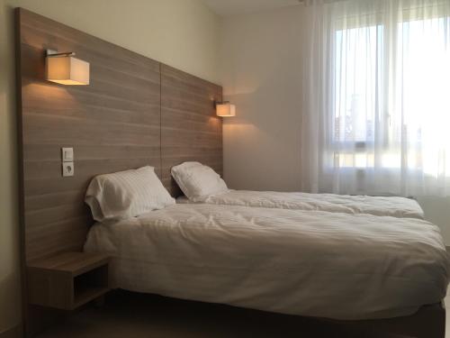 Un dormitorio con una cama grande y una ventana en Le Logis Dauphinois, en Roussillon en Isère
