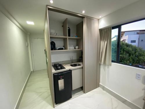 uma pequena cozinha com um lavatório e um fogão em Flat mar Porto de Galinhas em Porto de Galinhas
