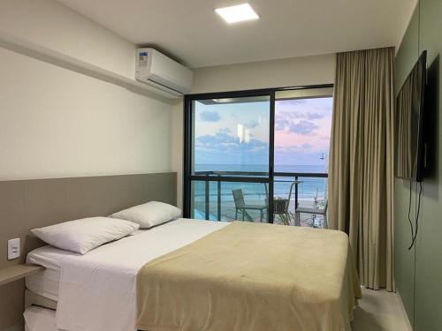 um quarto com uma cama e vista para o oceano em Flat mar Porto de Galinhas em Porto de Galinhas