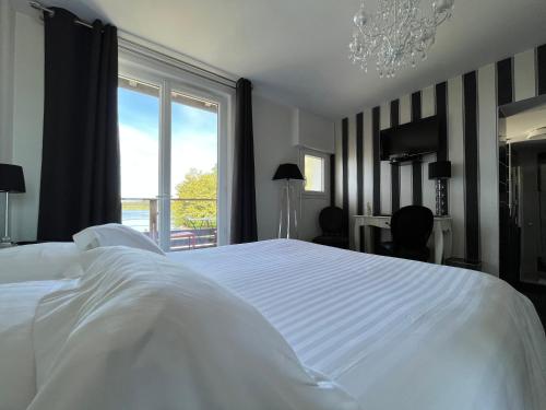 a bedroom with a large white bed and a window at L auberge de la pointe in Soustons