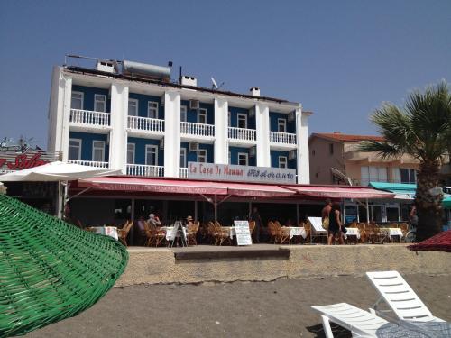 a large white building with a hammock in front of it at Olimpia Hotel in Fethiye