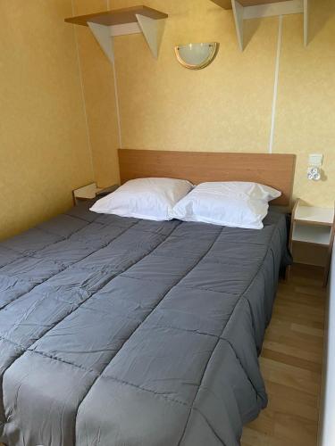 - un grand lit avec deux oreillers dans l'établissement Mobil-home au bord de l’eau, à Feins