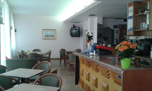 un ristorante con bar, tavoli e sedie di Hotel Nuova Doel a Sottomarina