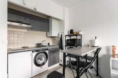 薩特魯維爾的住宿－Le cocon - DGI，厨房配有洗衣机和桌子