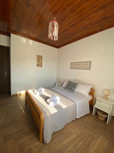 a bedroom with a bed and a wooden ceiling at Vasileris Home in Moúdhros