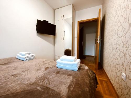 a bedroom with a bed with towels on it at Nirvana 02 in Zlatibor