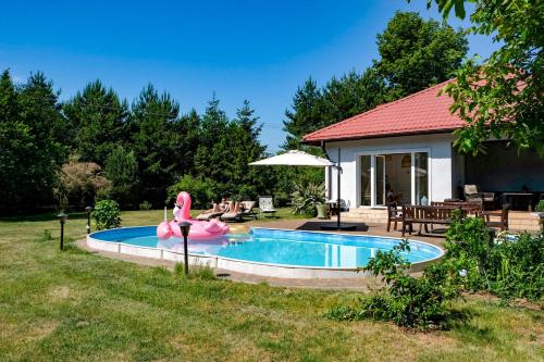 Una piscina en un patio con un flamenco rosa. en Zielone Siedlisko, 