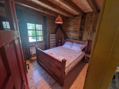 a bedroom with a bed in a log cabin at Vikendica Una in Kostajnica