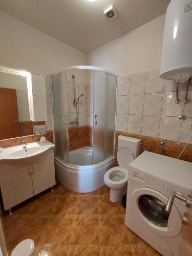 a bathroom with a shower and a toilet and a sink at Apartments Maris in Vranjic