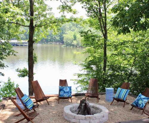 a group of chairs around a fire pit next to a lake at Riverbend Ranch for Family Fun on Smith Lake! Dogs welcome! in Crane Hill