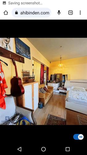 un salon avec un canapé et une chambre avec une guitare dans l'établissement Here 2 Sleep Here 2 Enjoy, à Istanbul