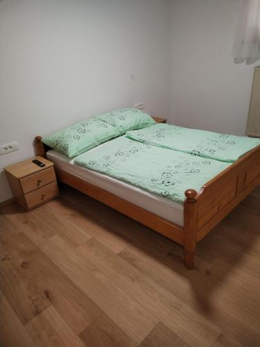 a bed sitting in a room with a wooden floor at Apartment Jalen in Bohinjska Bela