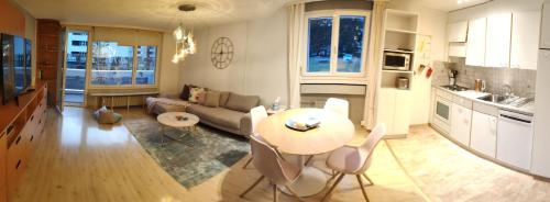 a kitchen and living room with a table and a couch at Central Serviced Apartments in Engelberg