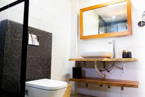 Giani Lodge في لوميه: حمام مع حوض ومرآة ومرحاض
