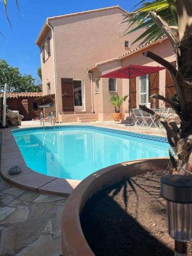 une grande piscine bleue devant une maison dans l'établissement Villa avec Piscine a St Marie la Mer, à Sainte-Marie-la-Mer